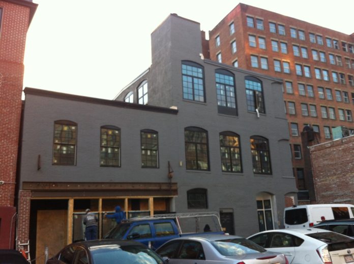 CONTRACTORS install a window at 91 Clemence St. in downtown Providence, being renovated by Cornish Associates as a new home for Betaspring and the Founders League. / PBN PHOTO/MARY MACDONALD