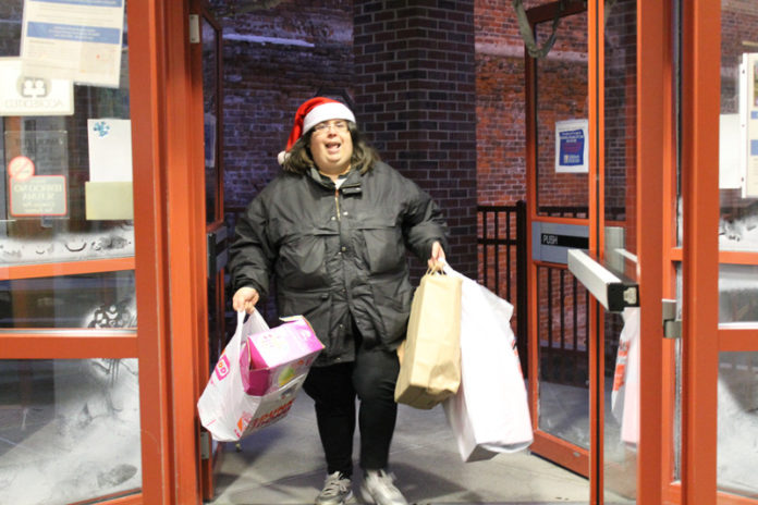 SPECIAL DELIVERY: Volunteer Julie Silva delivers bags from a truckload of toys to the 2014 Holiday Drive at Children's Friend in Providence. / COURTESY CHILDREN'S FRIEND