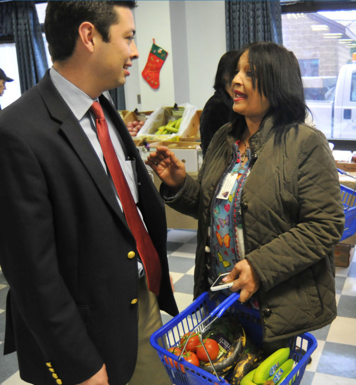 Central Falls Mayor James Diossa talked with shoppers, including visitor Candida Lombe Pina. / FRANK MULLIN/BROWN UNIVERSITY