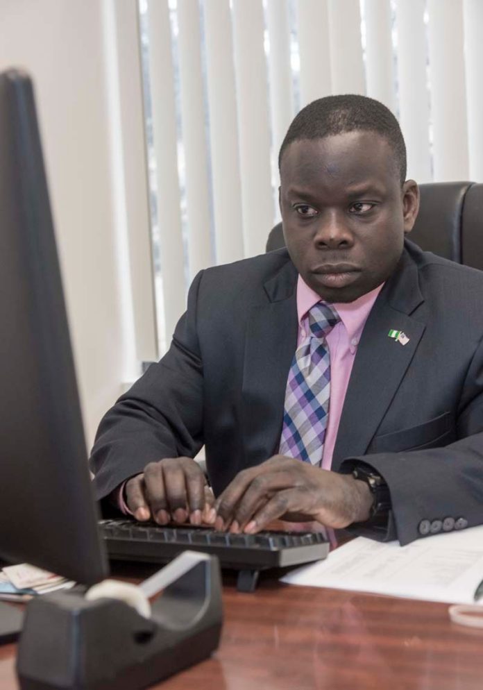 A BOOST FOR SMALL BUSINESS: Raphael Okelola, president of Roplab IT Solutions LLC, works on the home page for the website of the African Alliance of Rhode Island. His company received a $10,000 loan through a program administered by the Rhode Island Black Business Association. / PBN PHOTO/MICHAEL SALERNO