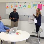 From left, Taylor Pickering, CJ Tsoumakas and Kathryn Johnson work on creating a business canvas.  
