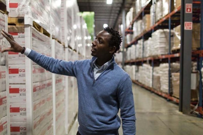 PART OF THE MISSION: Andrew Kamara, Edesia logistics/distribution manager, checks some of the nonprofit manufacturer's stock. / PBN PHOTO/RUPERT WHITELEY