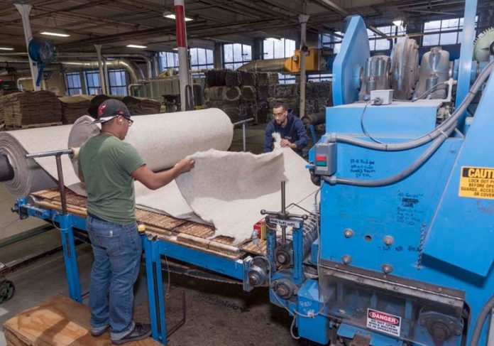 READY TO RIDE: Victor Bulux, left, and Luis Delacruz, machine operators at Bouckaert Industrial Textiles in Woonsocket, do a production run of equestrian saddle padding. / PBN PHOTO/MICHAEL SALERNO