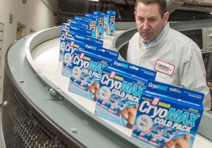 QUALITY CHECK: Al Greer, president and COO of Life Wear Technologies, examines boxes of the  CryoMAX eight-hour cold pack as they come down a line in North Kingstown. / PBN PHOTO/MICHAEL SALERNO