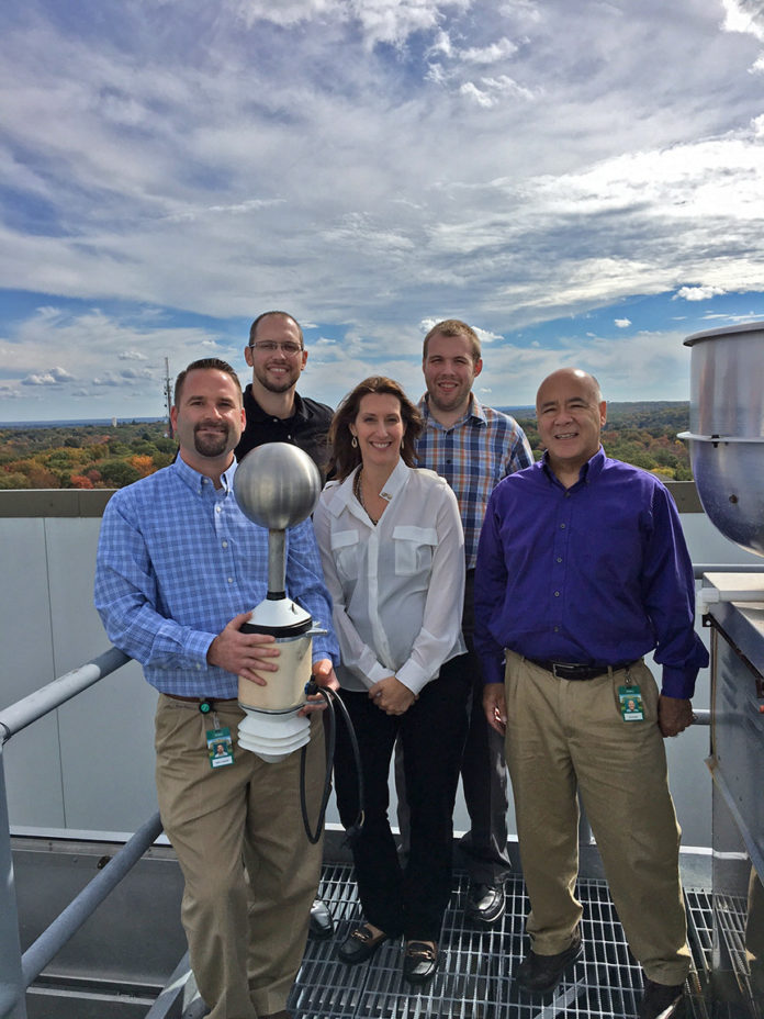 Amica employees Adam Kostecki, from left, Brian Leroux and Larry Brown, far right, are seen with Nicole Homeier, vice president of Understory Weather, and Alex Kubicek, CEO of Understory Weather, on the roof at Amica's corporate headquarters.