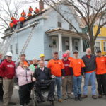 Representatives and volunteers from Operation Stand Down Rhode Island, Team Rubicon, the Home Depot Foundation and the office of U.S. Rep. Jim Langevin meet the family of Emile Johnson, a Vietnam War veteran whose roof was in dire need of repair. Langevin, sitting, center, through his staff, coordinated the repairs. / COURTESY OFFICE OF U.S. REP. JAMES R. LANGEVIN