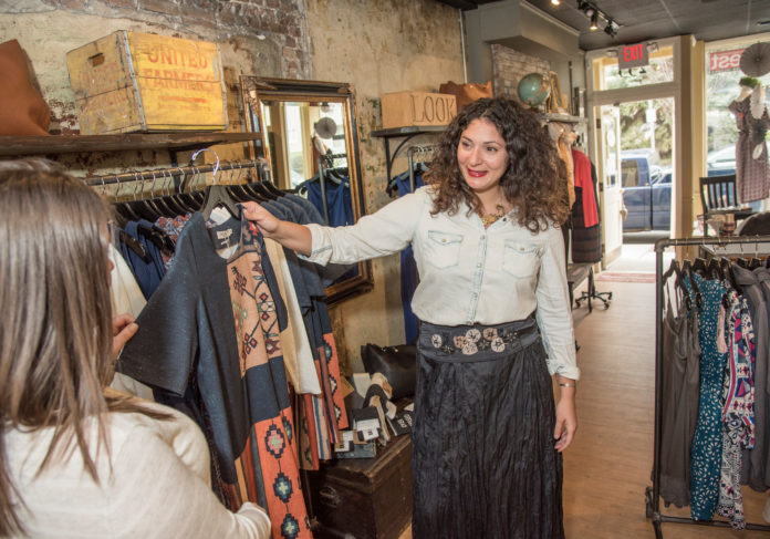 INTERNATIONAL FLAIR:  Natalie Morello, right, owner of Shoppe  Pioneer in Providence, helps Kelsey Cregg pick out clothing by a Spanish designer. / PBN PHOTO/ MICHAEL  SALERNO