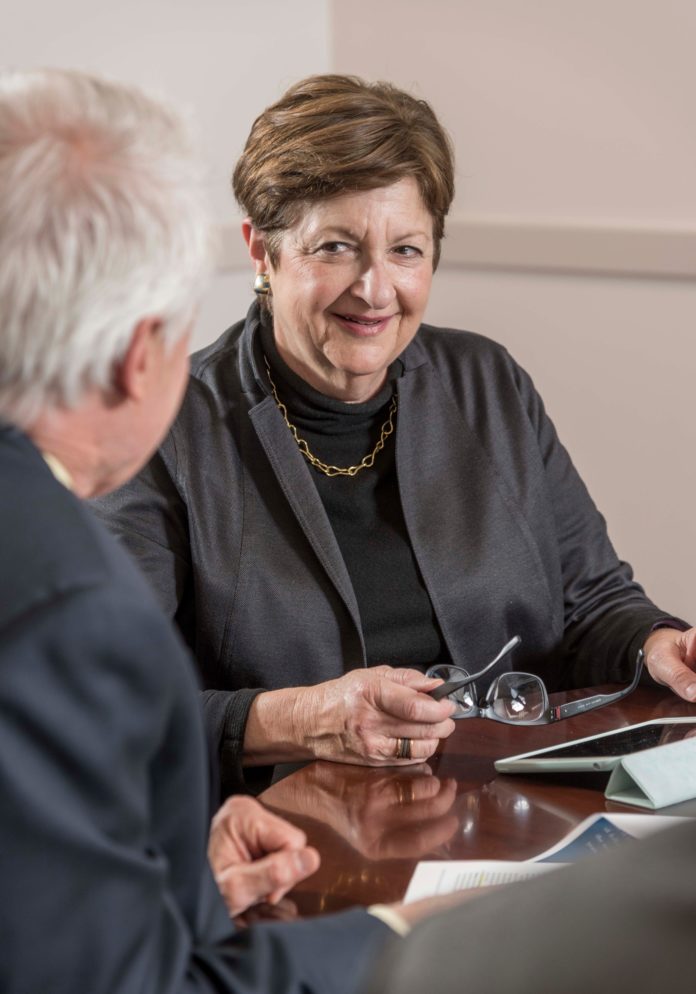 INSTITUTIONAL KNOWLEDGE: Merrill W. Sherman, chair of the R.I. Infrastructure Bank, speaks with her colleague Joseph R. Dewhirst, interim executive director, in Providence. Sherman, 67, is applying years of financial expertise she's accumulated to her position. / PBN PHOTO/MICHAEL SALERNO