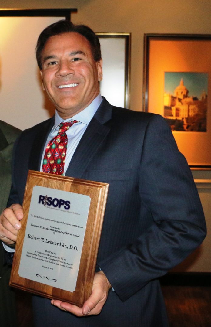 Dr. Robert Leonard is seen with the Laurence E. Bouchard Outstanding Service Award from the Rhode Island Society of Osteopathic Physicians and Surgeons. / COURTESY LEONARD HAIR TRANSPLANT ASSOCIATES