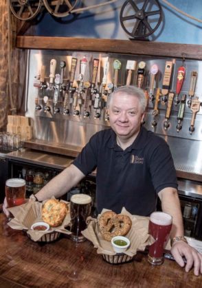 STEADY HAND: The Malted Barley owner Ron Koller, with three pints of ale and two baskets of handmade pretzels. He keeps a close eye on online reviews. / PBN PHOTO/ MICHAEL SALERNO