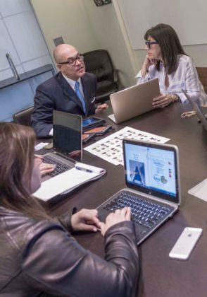 DIGITAL STRATEGY: Benrus CEO Giovanni Feroce discusses the company's social media strategy with employees Mikaela A. Condon, left, and Julie A. Kooloian. / PBN PHOTO/MICHAEL SALERNO