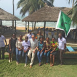 UNIVERSITY OF Rhode Island President David M. Dooley is shown sitting in a fishing canoe in Ghana with students who will attend graduate school at the university in the fall. / COURTESY PATRICIA MENSAH