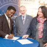 KOBI DENNIS of Unified Solutions, President Donald Farish of Roger Williams University and Dean of RWU School of Continuing Studies Jamie Scurry sign a memorandum of understanding to solidify their partnership incubator agreement which will create a direct pipeline for hundreds of inner city youth and adults to professional development and career opportunities. / COURTESY ROGER WILLIAMS UNIVERSITY