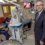 Surgery gets less invasive NEW TECHNIQUE: Thomas F. Patzelt, vice president of marketing at Medrobotics in Raynham, is seen in the company's lab with the Flexible Robotics System. Training on the equipment in the background is Dr. Giuseppe Spriano, left, an ENT surgeon from Italy, with Randy Haines, Medrobotics senior director of professional training and education. / PBN PHOTO/MICHAEL SALERNO