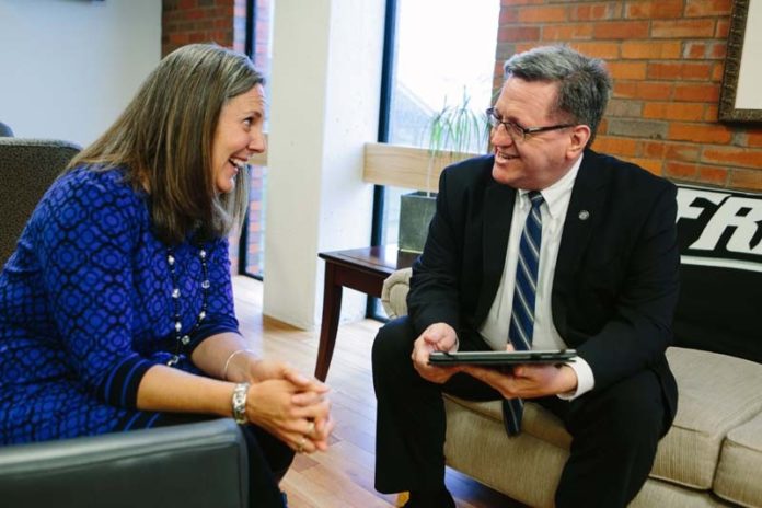 FULLY COMMITTED: John Sweeney, Providence College's CFO, meeting here with Kristine Goodwin, the vice president of student affairs, loves to solve problems for an institution at which his faith and values "tie so closely to the purpose of the institution." / PBN PHOTO/RUPERT WHITELEY