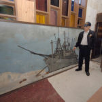 JIM RUGH looks at a mural depicting Seabees unloading supplies at a station in Antarctica. / PBN FILE PHOTO/BRIAN MCDONALD