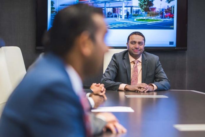 NEW DIRECTION IN HEALTH CARE: President and CEO Dr. Setul G. Patel, pictured in the background, helped found Neighbors Emergency Center in 2008. The free-standing emergency care business is entering the Rhode Island market, with two new centers in West Warwick and Bristol. / COURTESY NEIGHBORS EMERGENCY CENTER