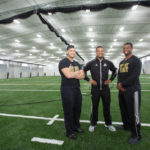 THREE MEMBERS OF BRYANT UNIVERSITY'S football team, from left, Josh Jefferson, Aaron Gilmer and Brandon Owens, pose in the new Conaty Indoor Athletic Center at the school's Smithfield campus. / COURTESY BRYANT UNIVERISTY