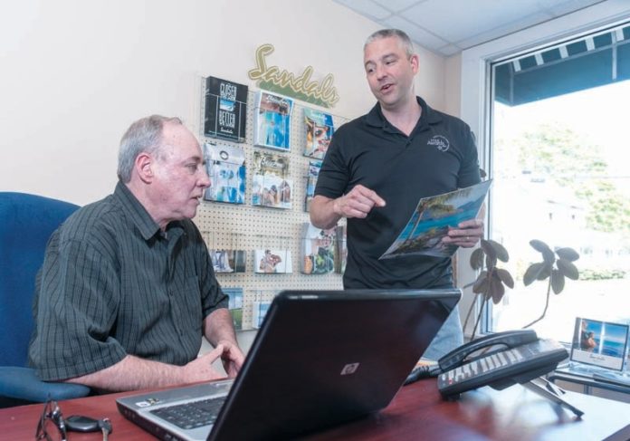 FULL ATTENTION: Mike Kennedy, left, and Michael Spremulli are owners of Captain Cruise & Crew Travel in East Providence, along with Bruce Atwell. They are leisure-travel specialists who strive to offer personalized service. / PBN PHOTO/MICHAEL SALERNO