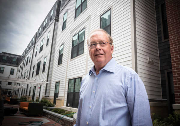 SHARP INCREASE: Gilbane Development Co. CEO and Chairman Robert Gilbane is seen in the courtyard of the apartment building at 257 Thayer St. in Providence. The building's assessment increased this year by 29 percent. / PBN FILE PHOTO/MICHAEL SALERNO