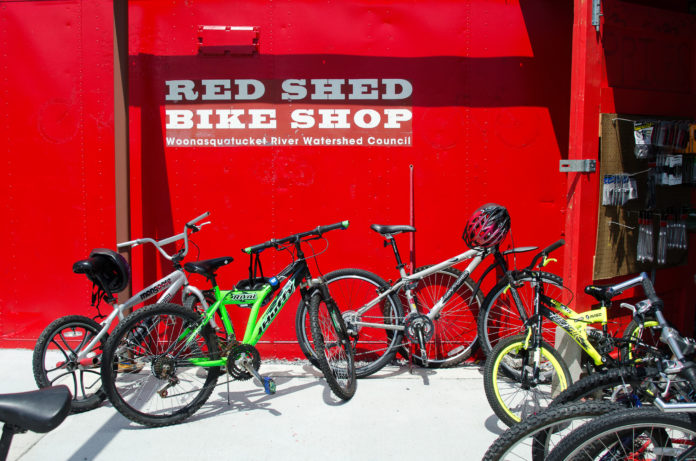 Furthering its campaign to get people riding bikes and keep unused cycles out of the river, the Woonasquatucket River Watershed Council is opening the Red Shed Bike Shop.