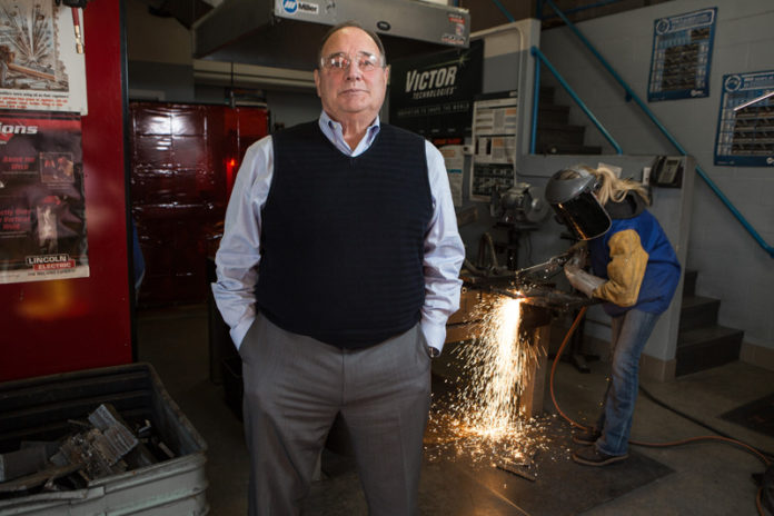 A MODEST SUCCESS: A shipbuilding program at New England Institute of Technology was successful at training Rhode Islanders for jobs in the industry, but like many similar programs, it is too small to fill the demand. Fred Santaniello, foreground, director of workforce development and programs at NEIT, is seen with Teddy Small, a participant in the SAMI program, who later found a job. / PBN FILE PHOTO/RUPERT WHITELEY