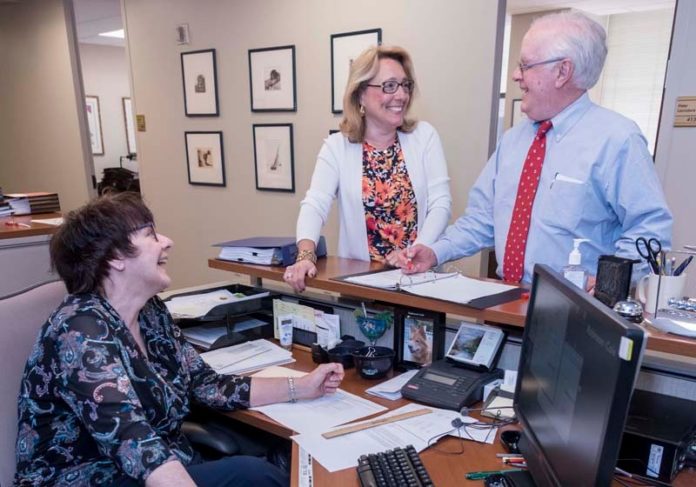 BUSINESS AND PLEASURE: From left, Brenda L. Vucci, legal administrative assistant, Heidi K. Seddon, legal administrative assistant, and Peter V. Lacouture, partner, share a laugh at Robinson & Cole at One Financial Plaza in Providence. / PBN PHOTO/MICHAEL SALERNO