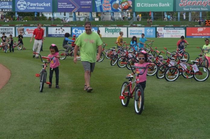 A FRESH SET OF WHEELS: Barnum Financial Group partnered with Foundation for Life to give bicycles to children who don't have them at McCoy Stadium in Pawtucket. / COURTESY BARNUM FINANCIAL GROUP