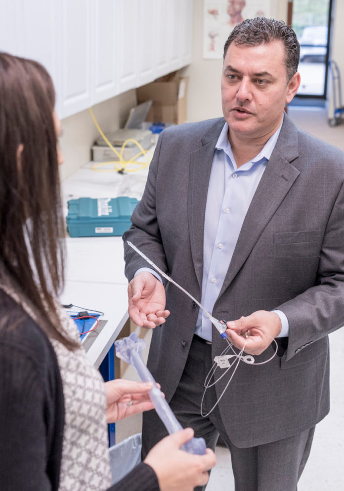 MANNY AVILA, president and CEO of IlluminOss Medical, is shown speaking with Amy O. Berman, vice president, clinical affairs, in the lab. Berman is holding a model of a bone and Avila has the IlluminOss implant that is inserted inside the bone and then hardened using light.

 / PBN FILE PHOTO/ MICHAEL SALERNO