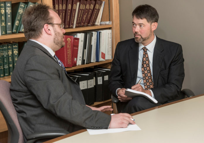 MAKING THE CUT: Erik Godwin, right, director of the Office of Regulatory Reform, and Derrick Pelletier, principal economic and policy analyst, are implementing a new law that will reduce all state regulations by 10 percent, or 2,700 pages. / PBN PHOTO/MICHAEL SALERNO