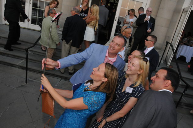 DANIELLE M. WARD, holding selfie stick at left, celebrates her being named a member of the 2016 Class of PBN's 40 Under Forty program. Standing behind the senior vice president for U.S. Trust is 2014 40 Under Forty honoree Amy Oakley, also a U.S. Trust staffer. / PBN PHOTO/MIKE SKORSKI