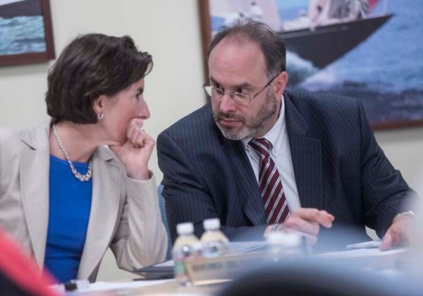 TEAM LEADERS: Gov. Gina M. Raimondo and Commerce Secretary Stefan Pryor confer at a recent Commerce Corp. board meeting. The pair have overseen a reorganization of the agency, which has seen state funding and staffing rise considerably since Raimondo took office in 2015. / PBN PHOTO/MICHAEL SALERNO