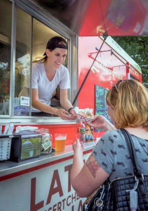 EASY TO ORDER AND EAT: Cate Latz of O'Crepe, The Rolling Creperie delivers a meal to Rachel Menard of Scituate at Roger Williams Park in Providence. / PBN PHOTO/MICHAEL SALERNO
