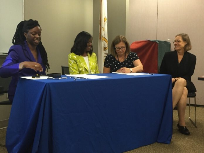 From left, Dr. Nicole Alexander-Scott, director of the Rhode Island Department of Health; Dr. Patrice Harris, board chair of the American Medical Association; Dr. Elinore McCance-Katz, chief medical officer for the Rhode Island Department of Behavioral Healthcare, Developmental Disabilities and Hospitals; and Dr. Sarah Fessler, president-elect of the Rhode Island Medical Society, at the ceremonial signing of a Memorandum of Understanding among the parties. / COURTESY R.I. DEPARTMENT OF HEALTH
