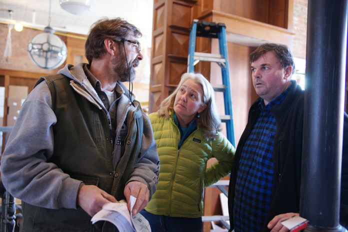 TURNING THE PAGE: Annie Philbrick, center, confers with Mark Hind of Peter Zuerner Design, left, and Rob Richins of general contractor Hammond Housecraft, in March, during the transformation of the former Savoy Hotel in Westerly into a bookstore. / PBN PHOTO/BRIAN MCDONALD
