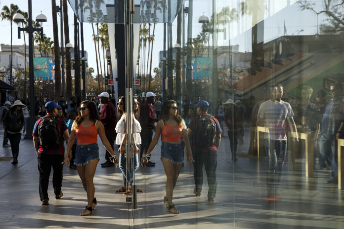 COMMERCE DEPARTMENT STATISTICS showed that U.S. consumer spending increased 0.3 percent in July, the fourth monthly increase in a row. Pedestrians walk past an Apple store in Santa Monica, Calif. / BLOOMBERG NEWS PHOTO/PATRICK FALLON