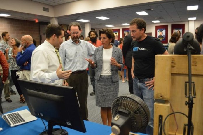 GOV. GINA M. Raimondo is shown speaking to a LaunchCode student about his project. She is joined by Sprout RI owner Zachary Weinberger and TechHire Rhode Island Executive Director Damian Ewens. / COURTESY GOVERNOR'S OFFICE