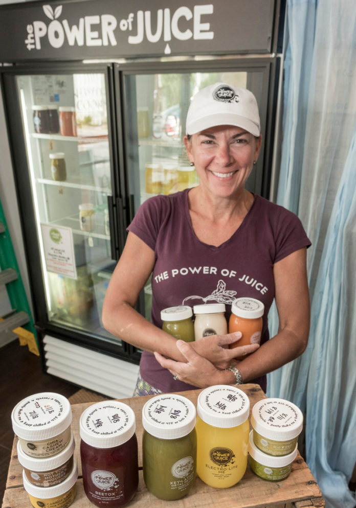 BACK TO BASICS: Brigid A. Rafferty, owner of The Power of Juice, a juice company focused on improving people's health using unprocessed ingredients, displays some of her products. / PBN PHOTO/MICHAEL SALERNO