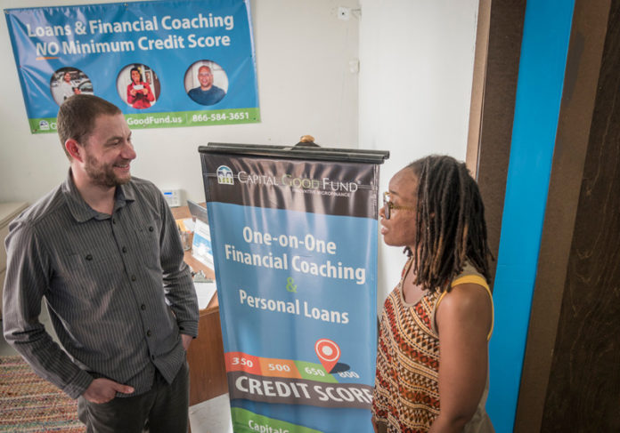 LENDING AN EAR: Andy Posner, founder and CEO of the Capital Good Fund, speaks with Chadria Major-Thomas, director of loan origination, at their Providence office. / PBN PHOTO/ MICHAEL SALERNO