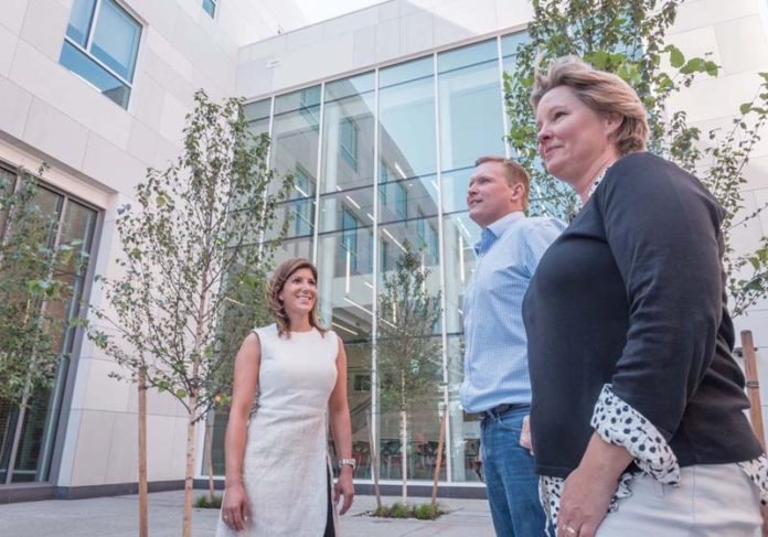 HOLDING COURT: From left, Ashley Iannuccilli, junior partner, Tim Brown, junior partner, and Kris Bradner, owner and senior partner of Birchwood Design Group LLC, in the courtyard of the new Johnson & Wales University engineering and science building. / PBN PHOTO/MICHAEL SALERNO