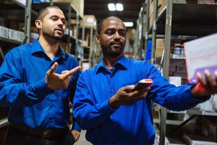 SIMPLE YET POWERFUL: Demonstrating Claflin 360, a handheld  inventory-control device the company rolled out in April 2015, are Jonathan Buchanan, left, Claflin Co. network manager, and Tony Suchite, IT operations manager. / PBN PHOTO/RUPERT WHITELEY