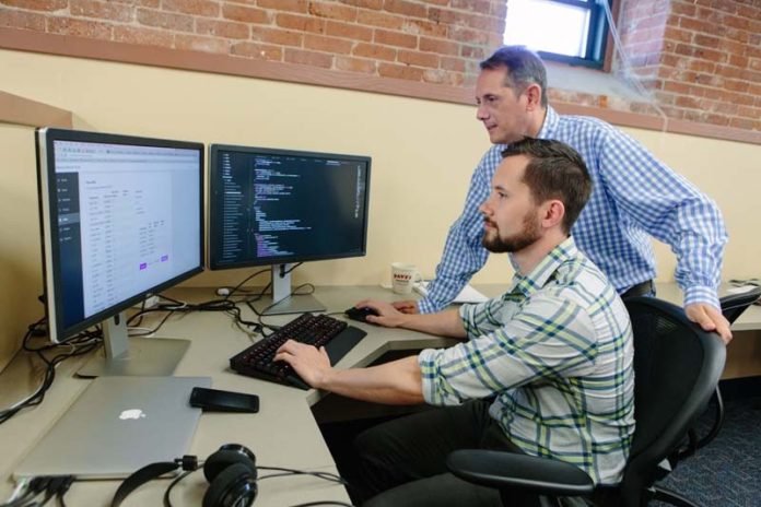 IN THE RIGHT PLACE AT THE RIGHT TIME: Datarista founder and CEO Pat Sabatino, standing, has had no problem finding the right talent in Providence, including Dave Counts, senior front-end engineer for the cloud-based, data-management startup. / PBN PHOTO/RUPERT WHITELEY