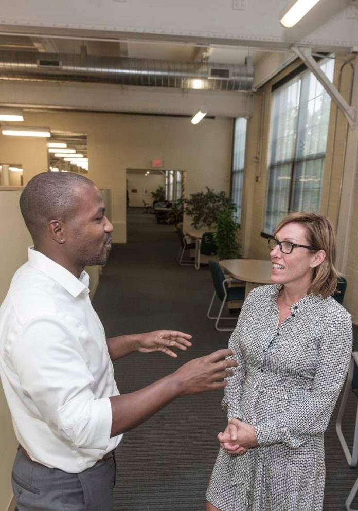 COLLABORATIVE EFFORT: Lara Salamano, the new chief marketing officer for R.I. Commerce Corp., speaks with Jay Johnson, director of business attraction. / PBN PHOTO/MICHAEL SALERNO