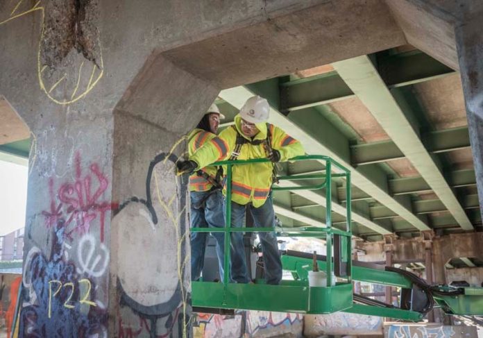 BENEATH THE SURFACE: Commonwealth Engineering Inspector Niverio Carvalho, left, and Fernando Faria, engineering technician, inspect the 6-10 connector in Providence. / PBN PHOTO/MICHAEL SALERNO