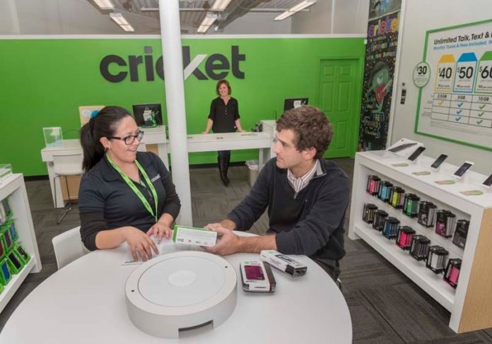 IN DEMAND: Store Manager Roxana Gutierez, for the Cricket Wireless store in Olneyville Square in Providence, helps city resident Chris Raia select a new phone. Kari Toth, Cricket New England market director, is in the background. / PBN PHOTO/MICHAEL SALERNO