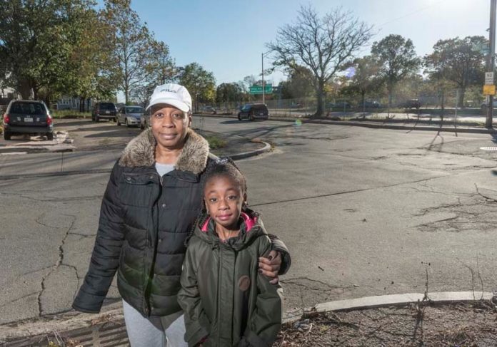 FEELING TRAPPED: The neighborhood abutting the area where Route 10 and Route 6 connect, near Chapin Avenue in Providence. Valerie Stephens and her 8-year-old daughter Nia live at 193 Chapin Ave. They are standing on the corner of Chapin Avenue and Service Road 1, with Route 10 in the background. / PBN PHOTO/ MICHAEL SALERNO