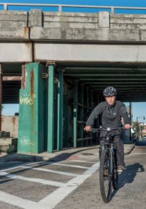 SHORT RIDE: Providence Mayor Jorge O. Elorza rides to work under the Route 6-10 connector  on Westminster St. in Providence. / PBN PHOTO/MICHAEL SALERNO