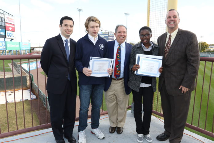 ON FRIDAY, Pawtucket Red Sox President Dr. Charles Steinberg, center, presented $10,000 college scholarships from the PawSox/Skeffington Charitable Foundation to Ethan Hoke, second from left, of the Calcutt Middle School in Central Falls and Charlisa Kollie, of Slater Junior High School in Pawtucket. He made the presentation along with Central Falls Mayor James Diossa, far left, and Pawtucket Mayor Donald Grebien, far right. / COURTESY THE PAWTUCKET RED SOX