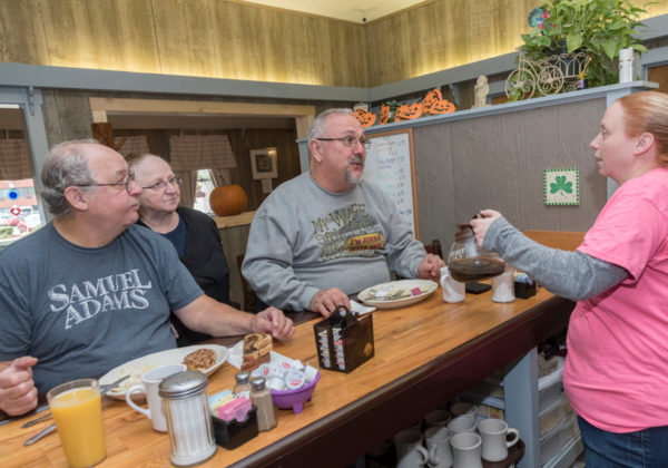 GOOD EATS: Judy Beauchemin, second from left, owner of Missy's Restaurant in Woonsocket, speaks with her husband, Roland, left, and Armand Tetreault of Woonsocket, as waitress Tabitha Westerhuis pours coffee. / PBN PHOTO/MICHAEL SALERNO