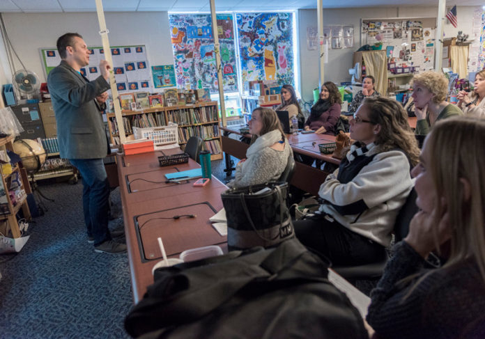 A WHOLE NEW WORLD: Highlander Institute is dedicated to spreading innovation to transform education. Here, left, Eric Butash, director of operations for the nonprofit, discusses smartphone potential with staff at Central Elementary School in Lincoln. / PBN PHOTO/MICHAEL SALERNO